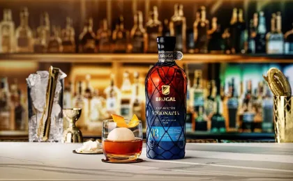 Botella de Brugal Colección Visionaria Coconut junto a un cóctel de ron