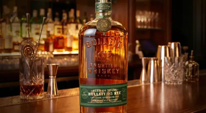 Bulleit Rye 20 años edición limitada Botella de Bulleit Frontier Whiskey junto a una copa de whisky de centeno