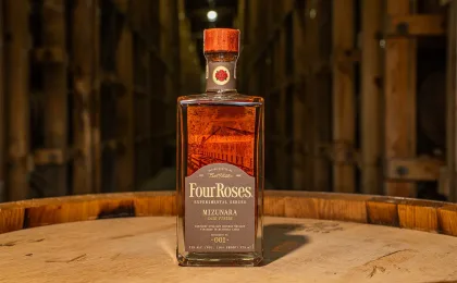 Bottiglia di bourbon Four Roses accanto a botti in una distilleria del Kentucky