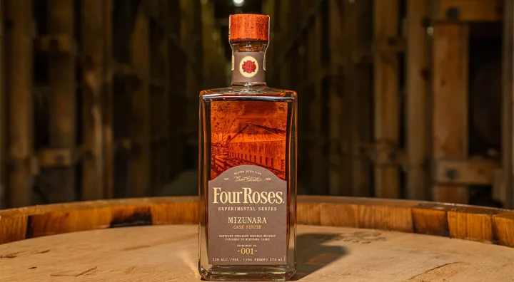 Botella de bourbon Four Roses junto a barricas en una destilería de Kentucky