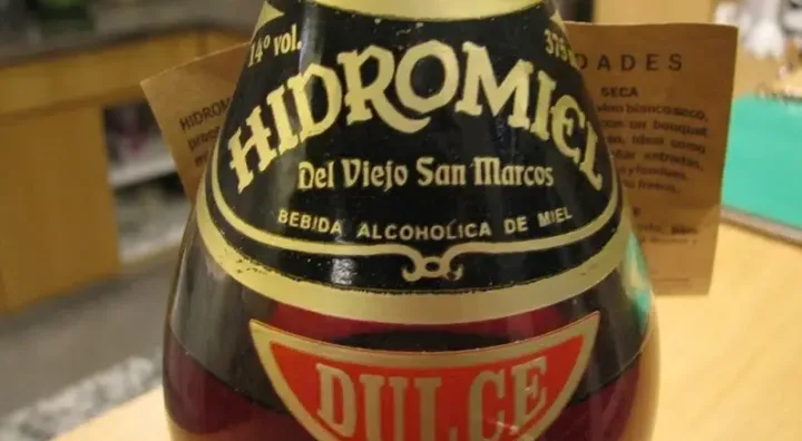 Hidromiel elaborado con miel y fermentación tradicional Vaso de hidromiel junto a miel como base de la bebida fermentada