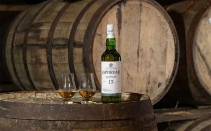 Laphroaig 15 con due bicchieri da degustazione su botte di rovere