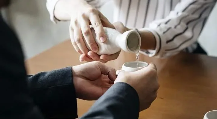 Saké japonais, élaboration traditionnelle et service Bouteilles et coupes de saké japonais prêtes pour le service