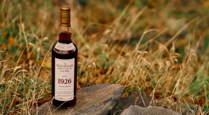 Alla scoperta della storia della bottiglia Macallan 1926 La storica bottiglia di Macallan 1926 accanto alla sua confezione