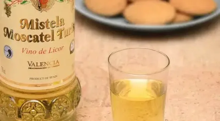 Copa de mistela dulce junto a uvas y aromas tradicionales