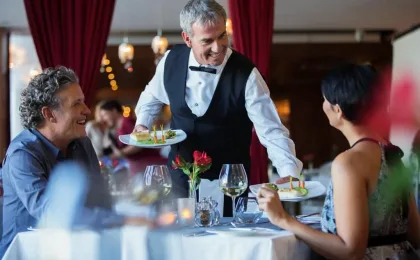 Serveur présentant une bouteille de vin lors d’un service en restaurant
