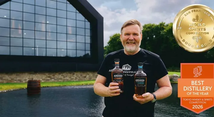 James Doherty pose avec deux whiskeys de la distillerie