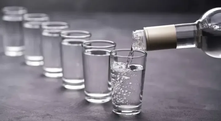Wodka und die historische Herkunft der weißen Spirituose Flasche und Glas Wodka als Symbol der klaren weißen Spirituose