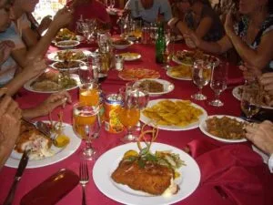Table avec des assiettes et des personnes assises autour.