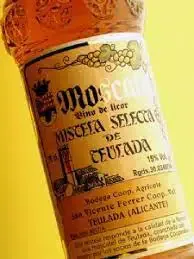 Bottle and glass of mistela served as an aperitif