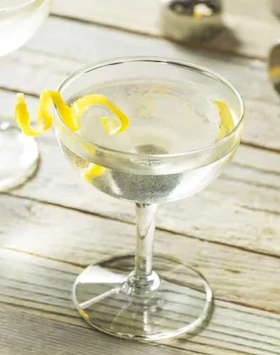 Cocktailglas mit Wermut, Gin und Zitrone, ein klassischer Dry Martini