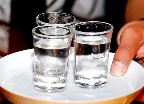 Drei kleine niedrige Gläser mit Gin
